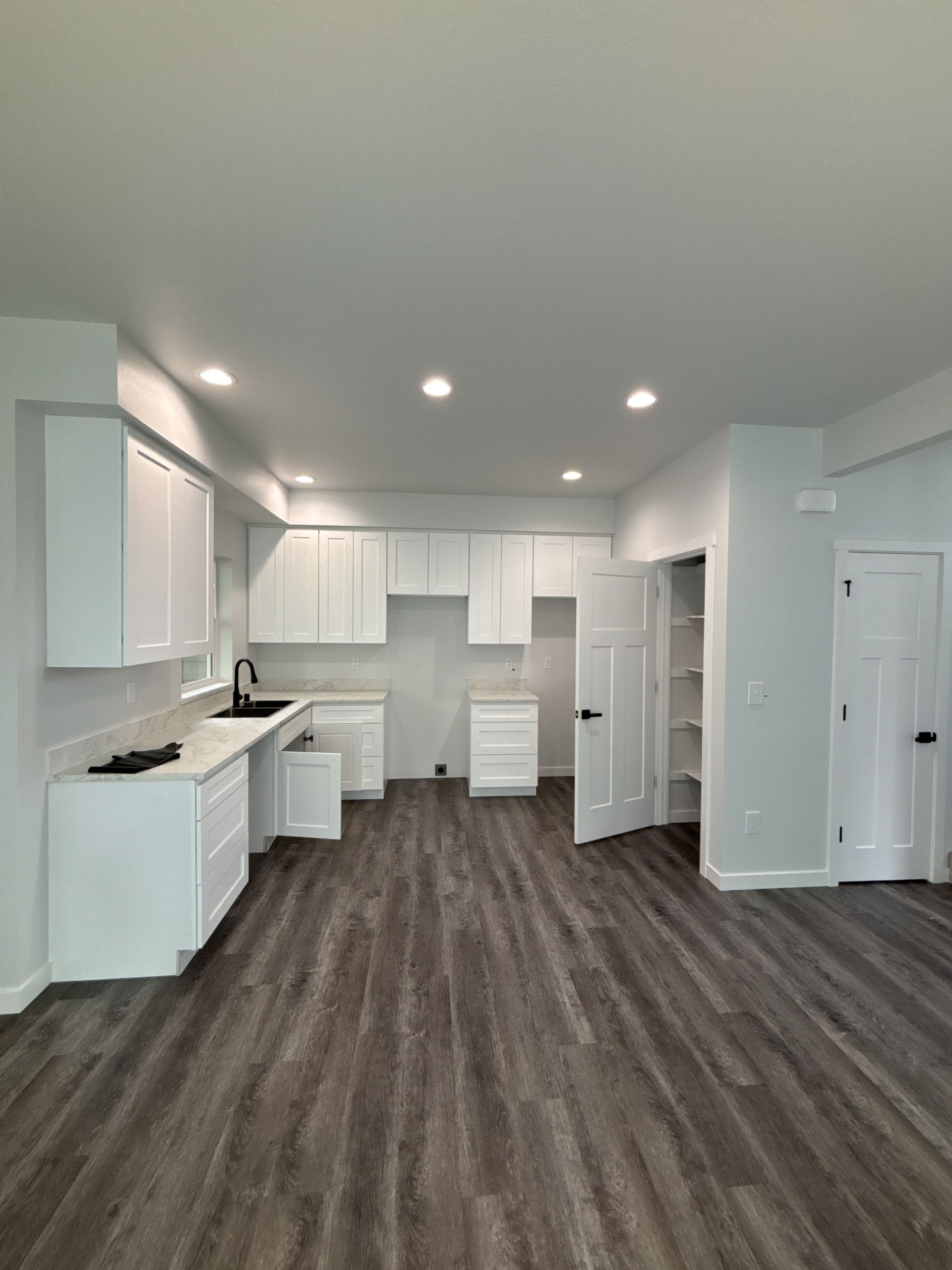Interior of Skagit Habitat for Humanity's 8-home construction project in Anacortes, Washington. Brown floors, with finished cabinets and light colored kitchen counters.
